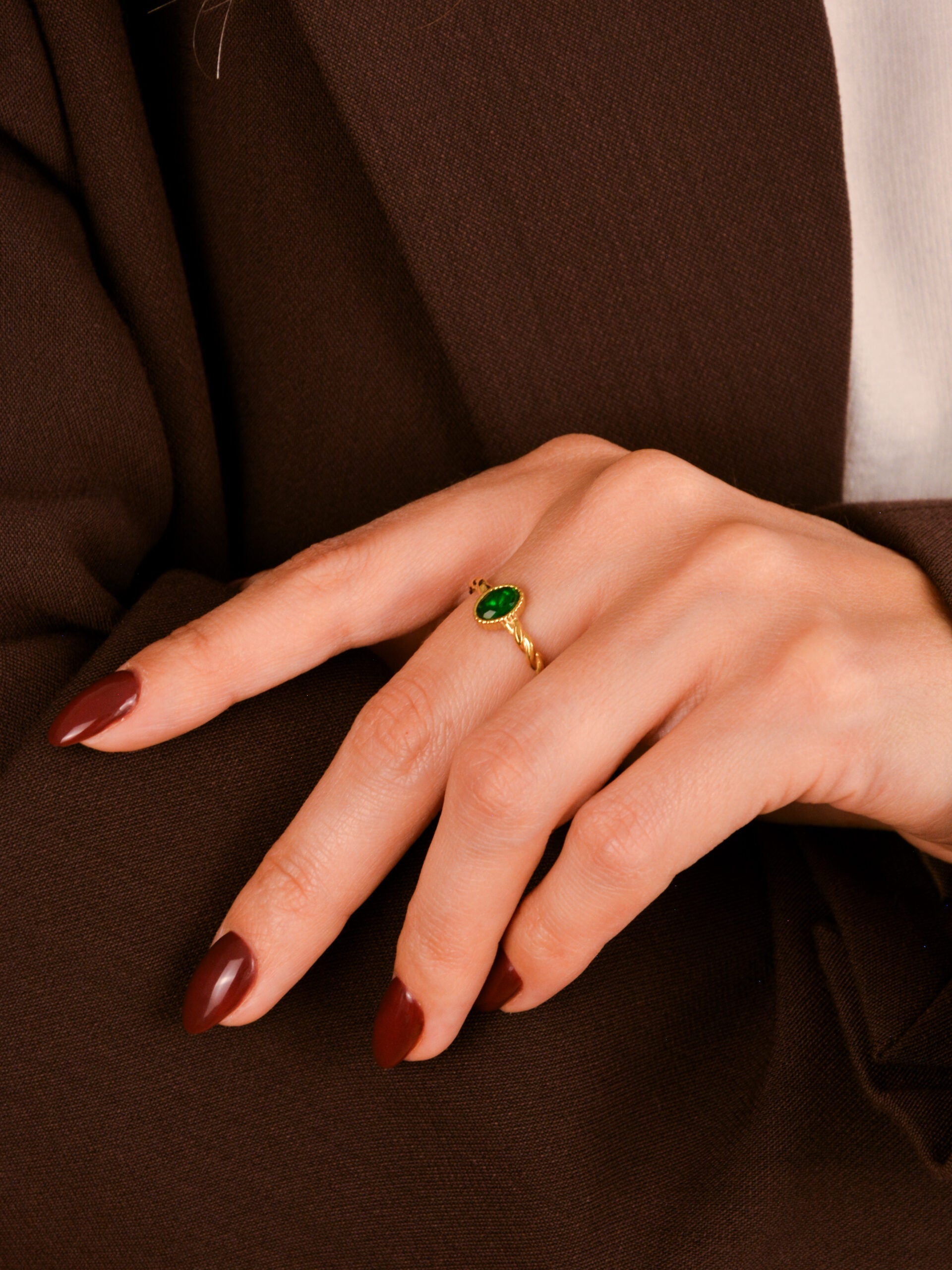 O Anel em Aço Dourado Torcido com Pedra Verde é uma verdadeira joia de presença — elegante, ousado e cheio de charme.