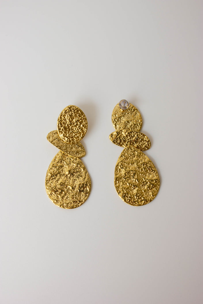 Long, textured, gold-plated steel earrings with geometric design.