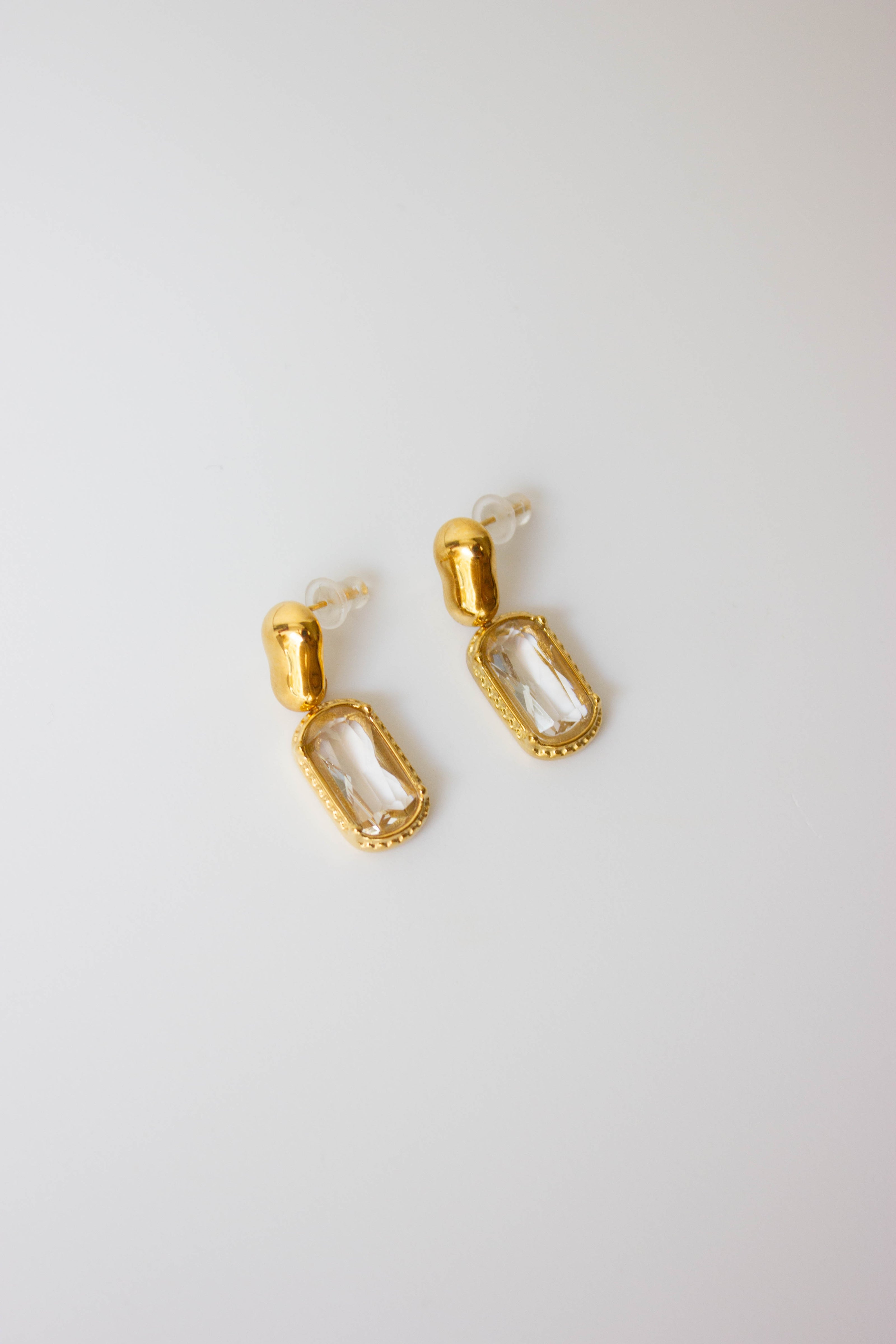 Gold-plated steel earrings with green or clear stone.
