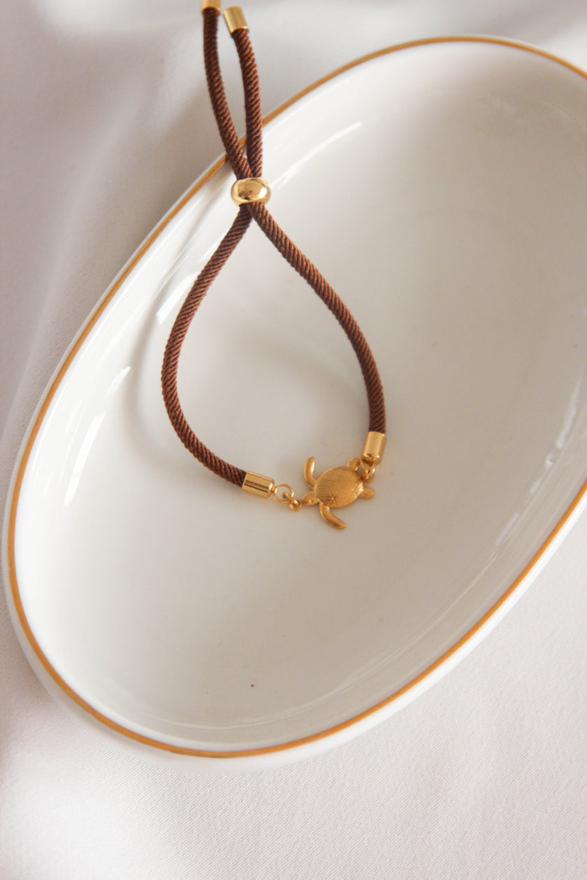 Pulseira Castanha com Pendente Tartaruga em Aço