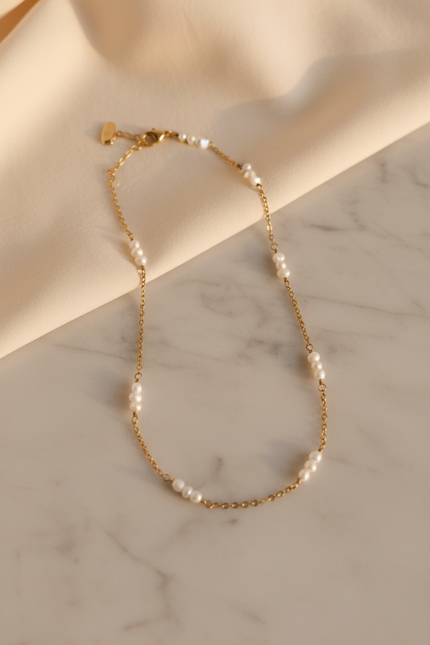 Colar dourado com pérolas - lifestyle mármore e tecido creme